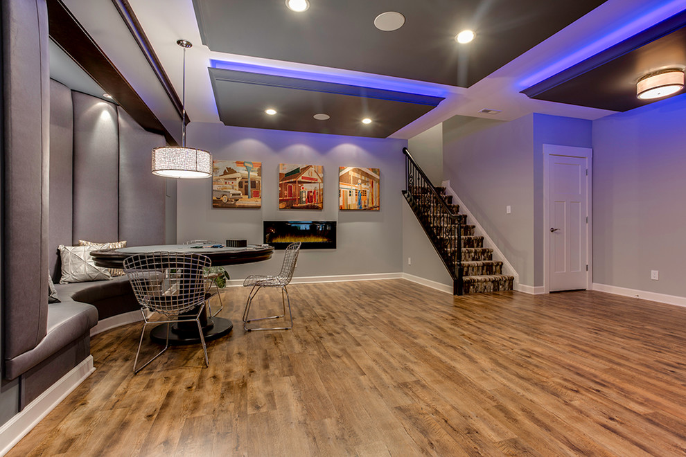 Example of a huge trendy walk-out light wood floor basement design in Baltimore with gray walls, a ribbon fireplace and a metal fireplace