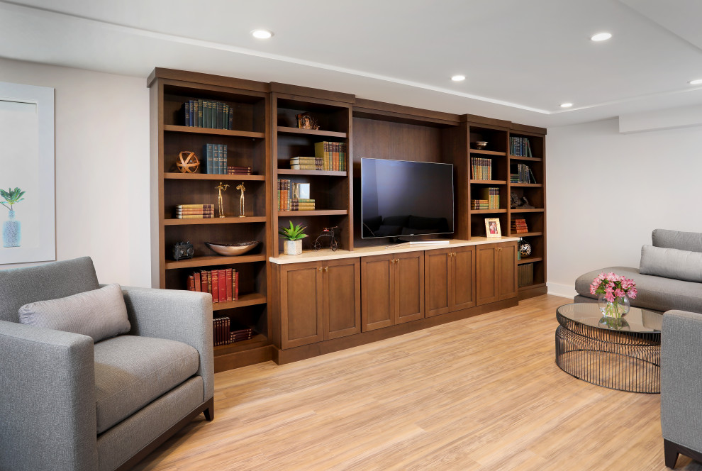 This is an example of a large classic look-out basement in Chicago with white walls, laminate floors, beige floors, a vaulted ceiling and wainscoting.