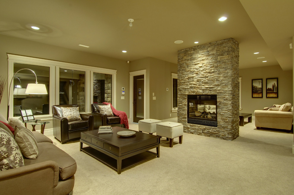 Inspiration for a large transitional walk-out carpeted basement remodel in Calgary with beige walls, a standard fireplace and a stone fireplace
