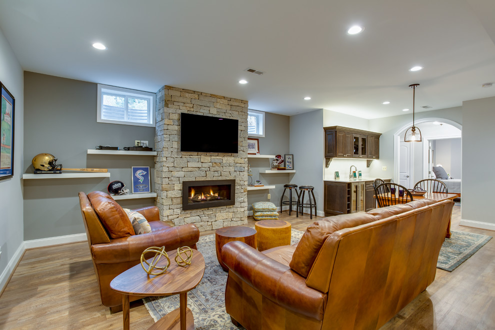 Expansive traditional walk-out basement in DC Metro with vinyl flooring, a standard fireplace and a stone fireplace surround.