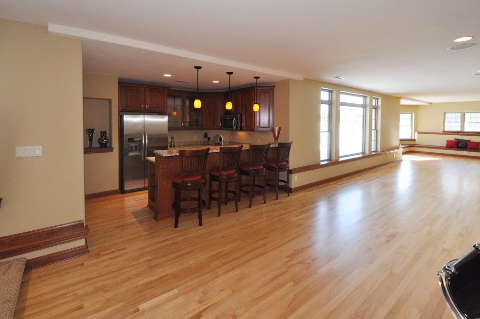 Huge transitional look-out light wood floor basement photo in Milwaukee with beige walls