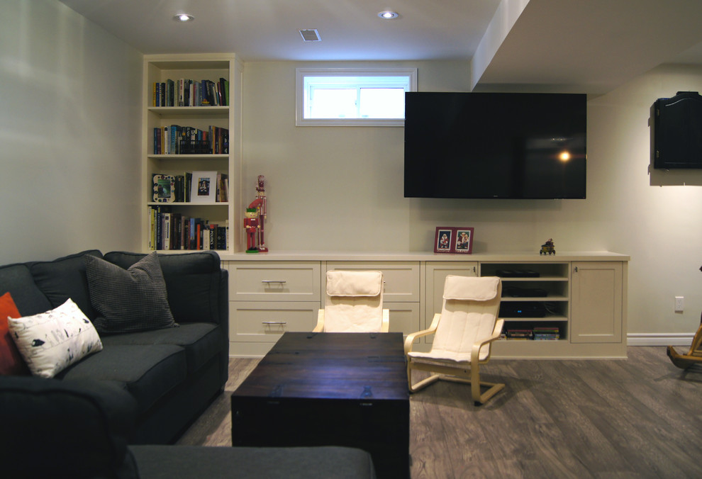 Photo of a medium sized traditional basement in Toronto with grey walls, laminate floors, no fireplace and grey floors.