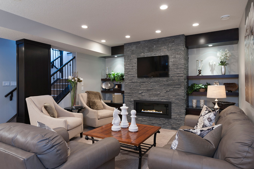 Example of a transitional underground basement design in Calgary with a ribbon fireplace and a stone fireplace