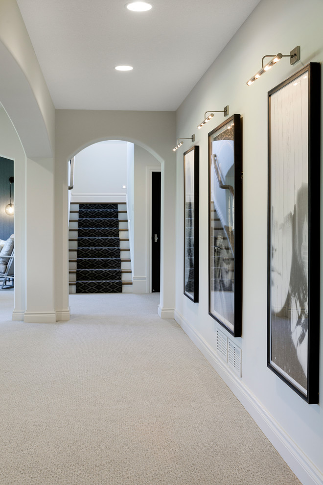 Imagen de sótano con puerta extra grande con paredes blancas, moqueta y suelo beige