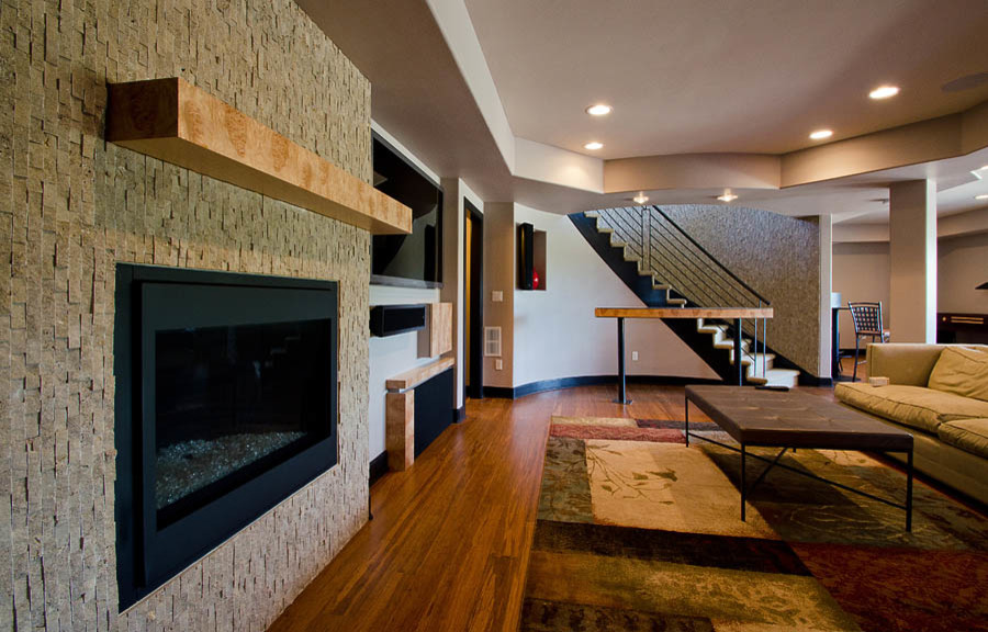 Inspiration for an expansive contemporary walk-out basement in Denver with bamboo flooring, a standard fireplace and a stone fireplace surround.