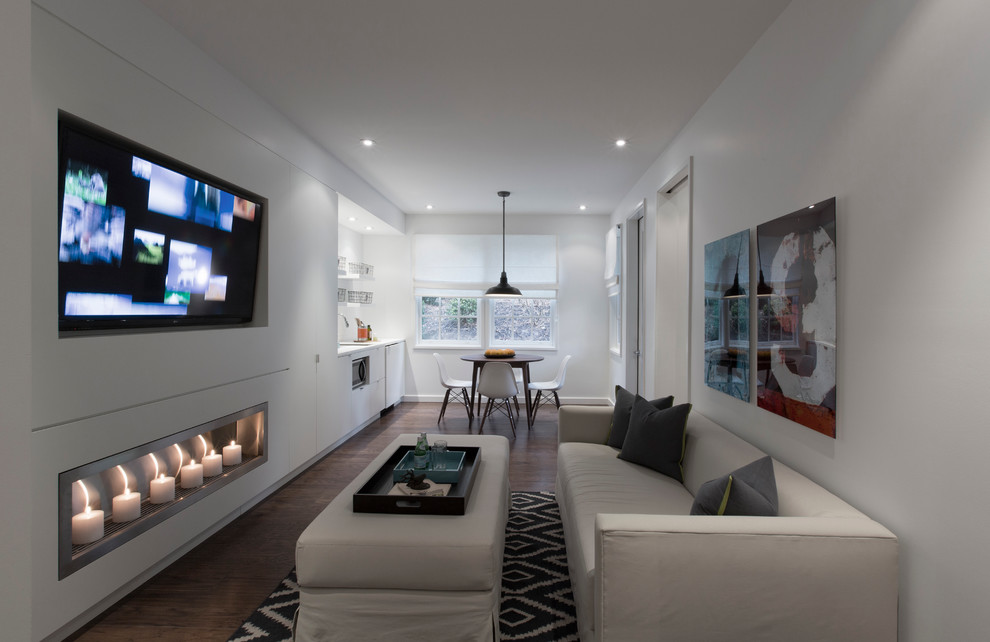 Стильный дизайн: гостиная комната в современном стиле с белыми стенами, горизонтальным камином и темным паркетным полом - последний тренд