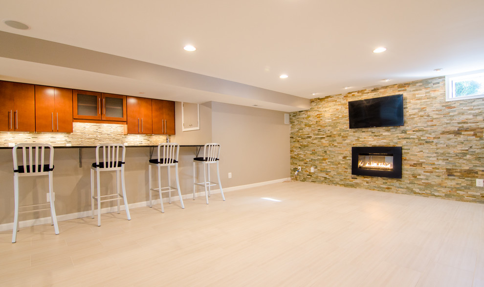 Basement - huge contemporary walk-out porcelain tile basement idea in DC Metro with beige walls and a stone fireplace