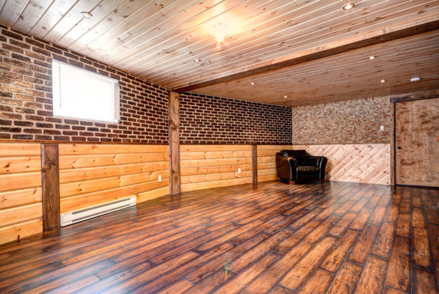 Kleines Rustikales Untergeschoss mit grauer Wandfarbe und braunem Holzboden in Charlotte