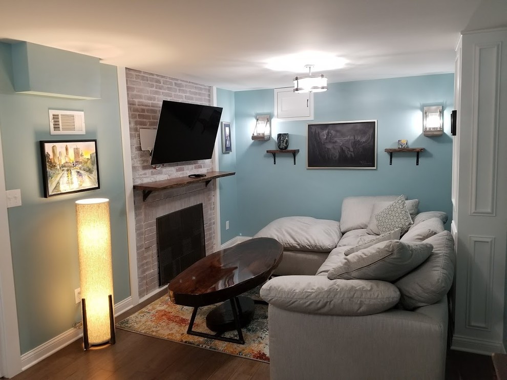 Inspiration for a mid-sized underground medium tone wood floor and brown floor basement remodel in Indianapolis with blue walls, a standard fireplace and a brick fireplace