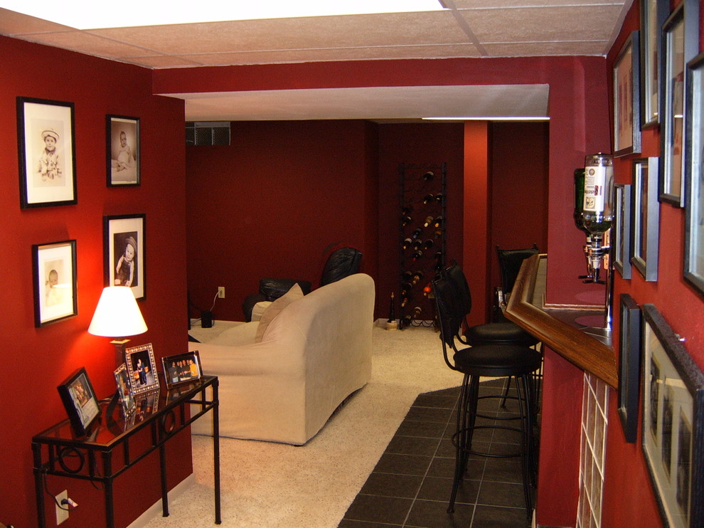 Foto di una taverna classica interrata con pareti rosse, moquette e nessun camino