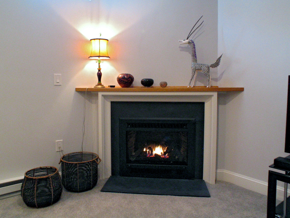 Example of a huge trendy underground light wood floor basement design in Boston with gray walls, a corner fireplace and a wood fireplace surround