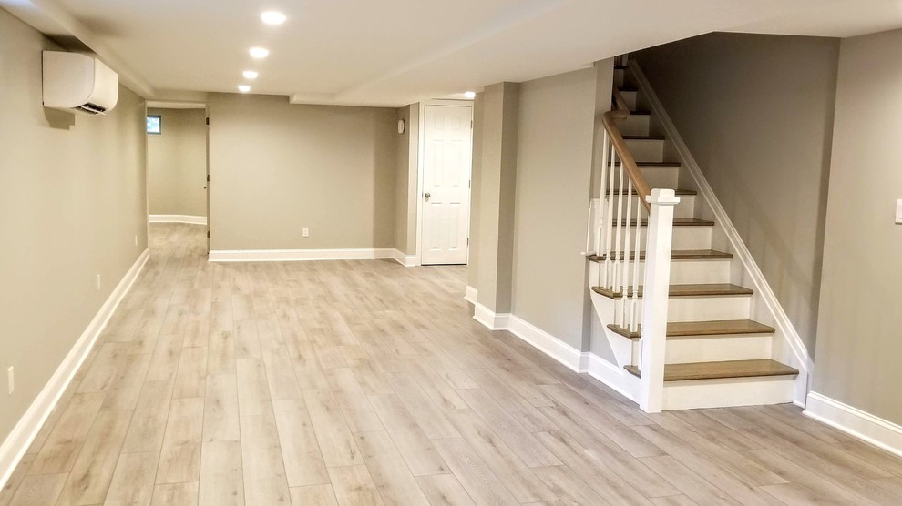 Large contemporary look-out basement in New York with beige walls, vinyl flooring and beige floors.