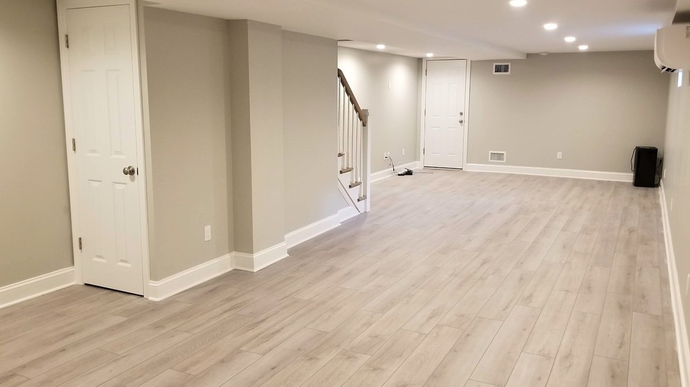 Basement - large contemporary look-out vinyl floor and beige floor basement idea in New York with beige walls
