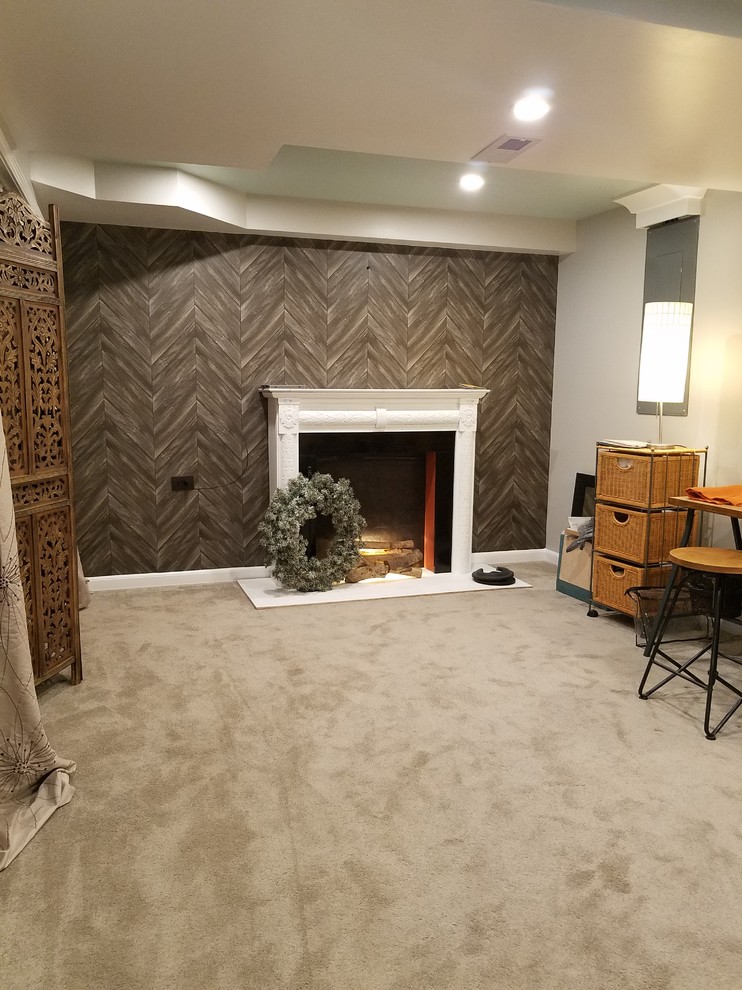 Medium sized industrial fully buried basement in Chicago with grey walls, carpet, a standard fireplace, a plastered fireplace surround and grey floors.