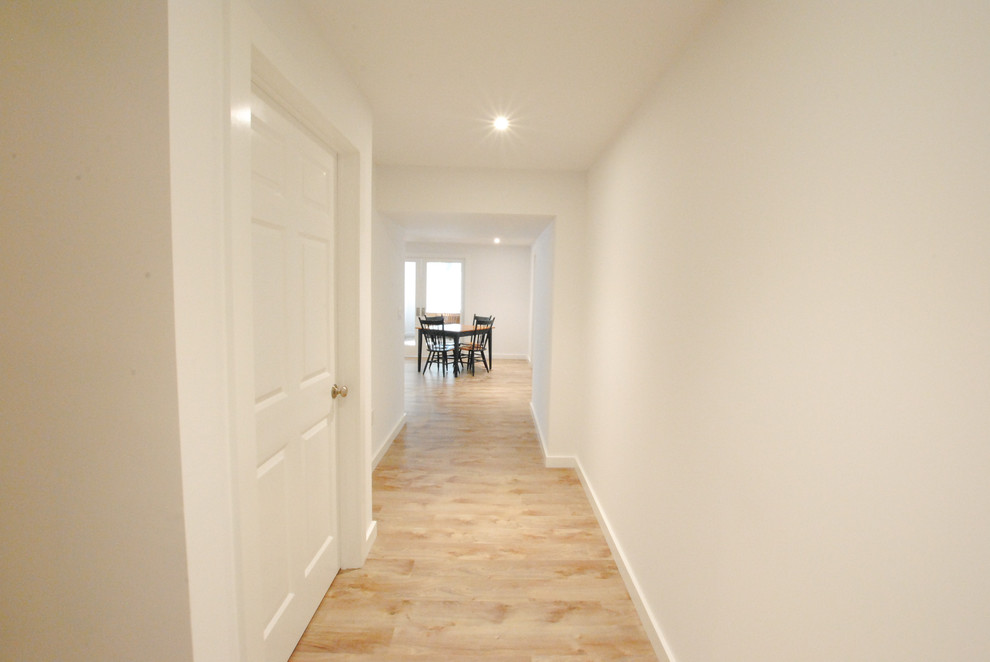 Inspiration for a mid-sized timeless walk-out vinyl floor and beige floor basement remodel in New York with white walls