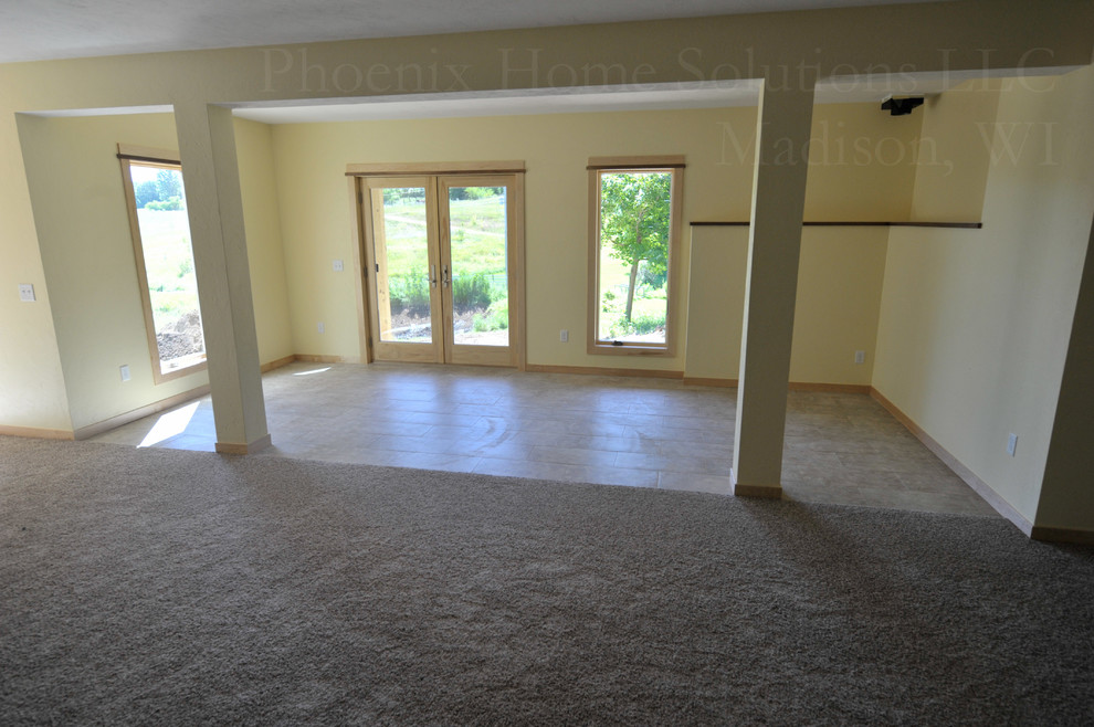Medium sized classic walk-out basement in Milwaukee with yellow walls, porcelain flooring and no fireplace.