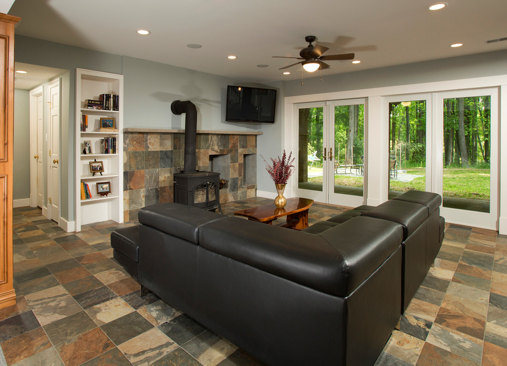 Design ideas for a large classic walk-out basement in DC Metro with grey walls, slate flooring, a wood burning stove and a stone fireplace surround.