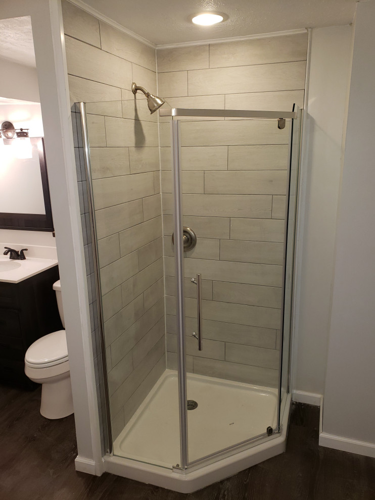 На фото: огромная ванная комната в стиле рустика с серыми стенами, полом из ламината, коричневым полом и кирпичными стенами с