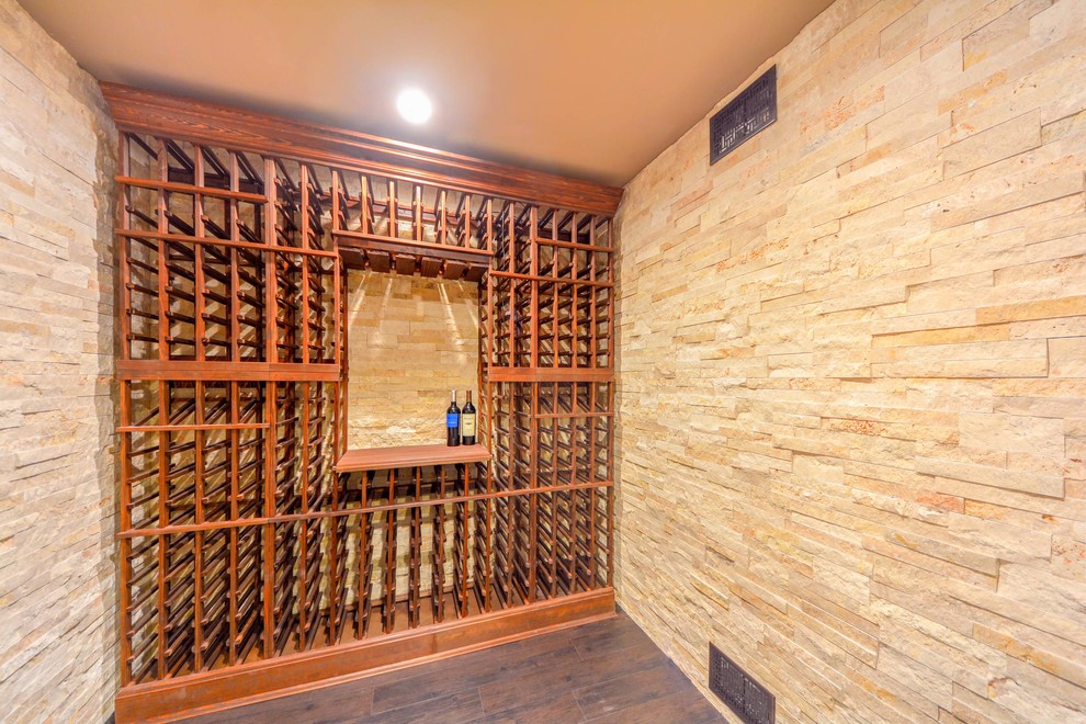 Idée de décoration pour une cave à vin tradition de taille moyenne avec un sol en vinyl, un présentoir et un sol marron.