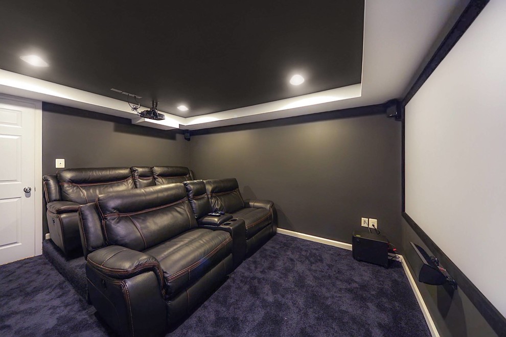 This is an example of a medium sized traditional home cinema in DC Metro with black walls, carpet and purple floors.