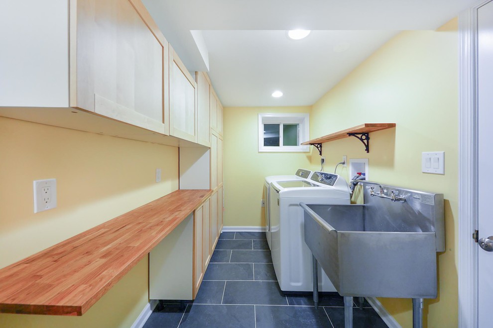 Cette image montre un petit sous-sol traditionnel donnant sur l'extérieur avec un mur beige et un sol en bois brun.