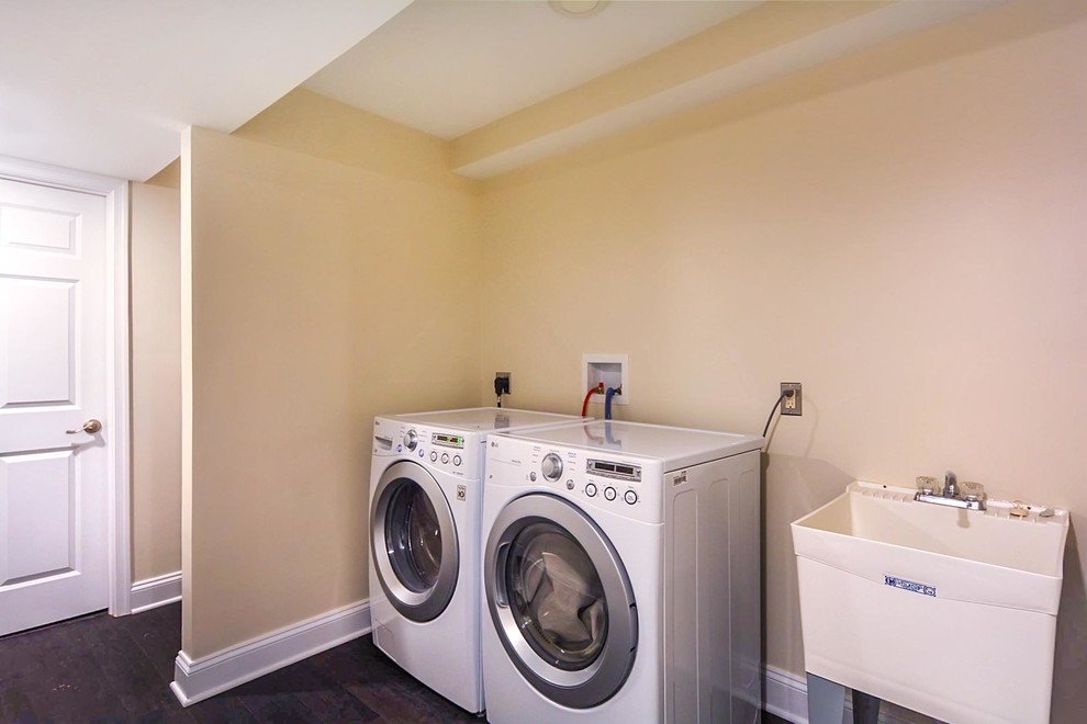 Design ideas for a small classic separated utility room in DC Metro with white walls, an utility sink, a side by side washer and dryer, black floors, feature lighting and vinyl flooring.