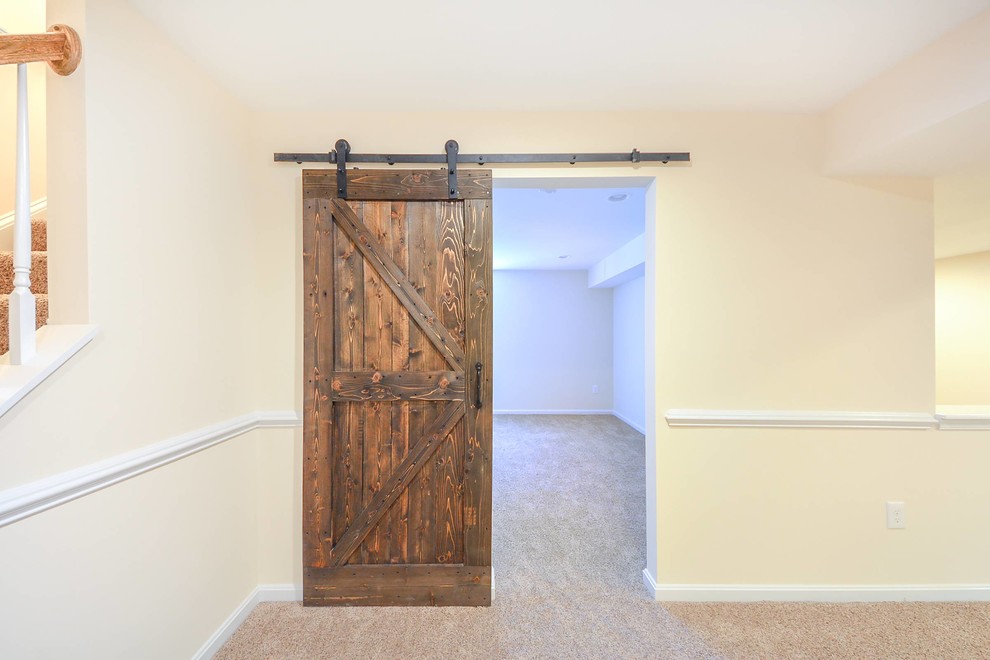 Ejemplo de sótano con puerta tradicional renovado de tamaño medio con paredes beige y moqueta