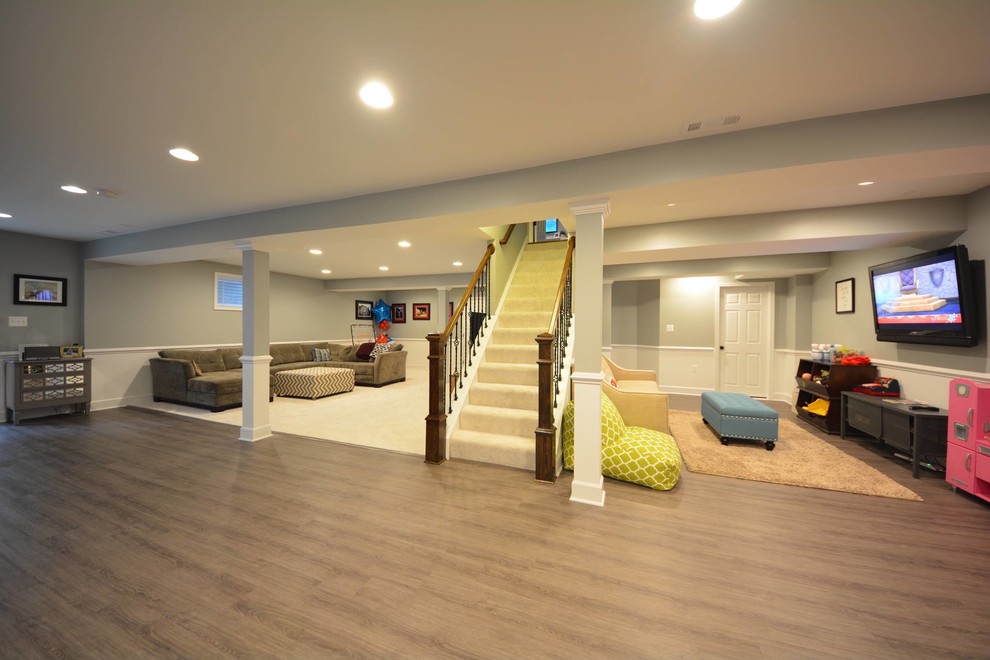 Large contemporary walk-out basement in DC Metro with grey walls, no fireplace, dark hardwood flooring and a dado rail.