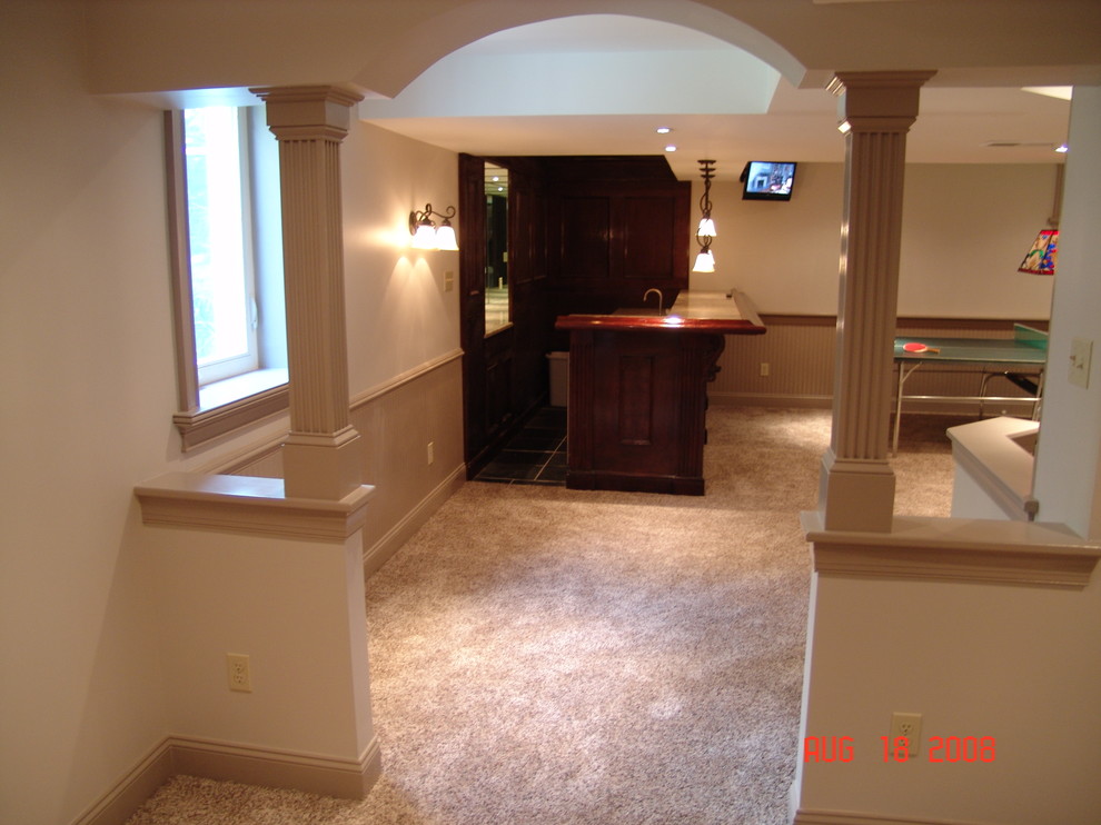 Inspiration for a large classic fully buried basement in Philadelphia with beige walls, carpet, a corner fireplace, a stone fireplace surround and beige floors.