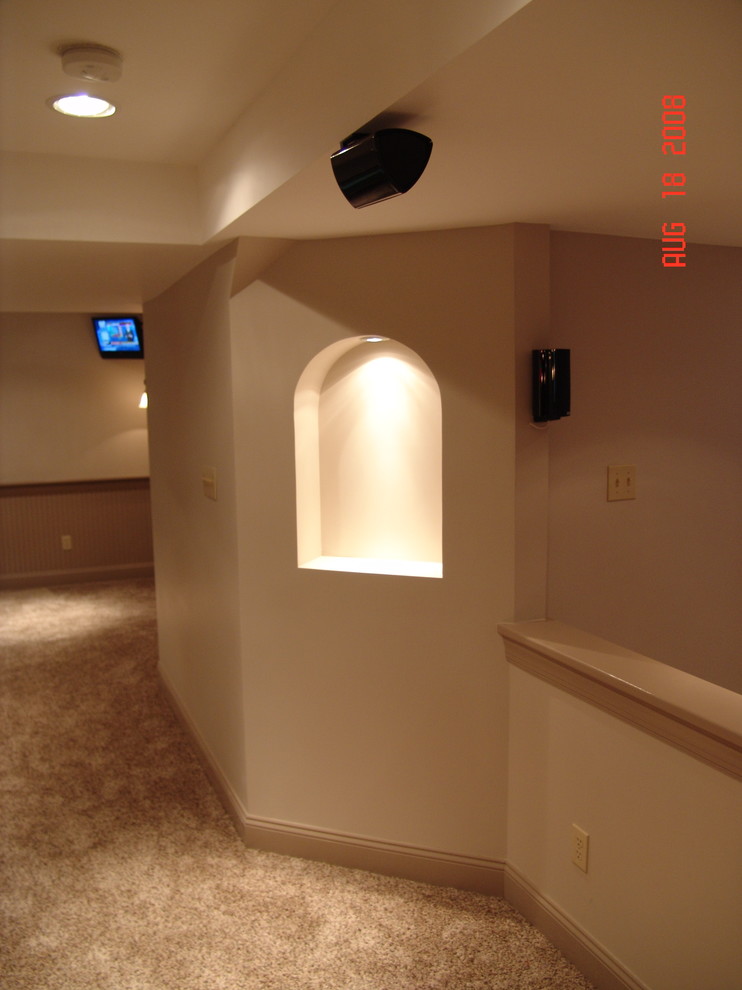Foto de sótano en el subsuelo clásico grande con paredes beige, moqueta, chimenea de esquina, marco de chimenea de piedra y suelo beige