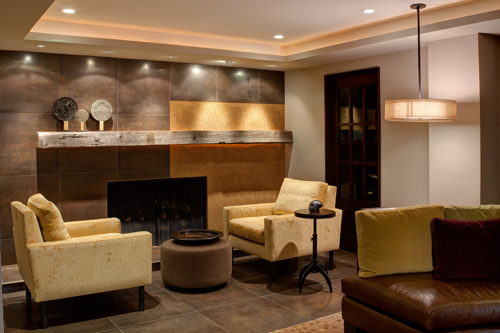 Стильный дизайн: гостиная комната в современном стиле с бежевыми стенами, стандартным камином, фасадом камина из плитки, полом из керамической плитки и коричневым полом - последний тренд
