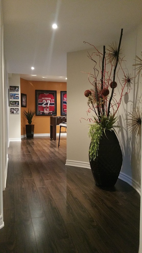 Design ideas for a medium sized contemporary fully buried basement in Montreal with multi-coloured walls, dark hardwood flooring, no fireplace and brown floors.
