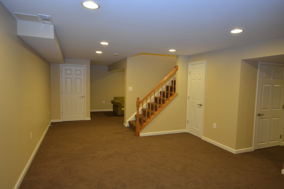 Example of a large classic walk-out carpeted and brown floor basement design in Baltimore with yellow walls and no fireplace