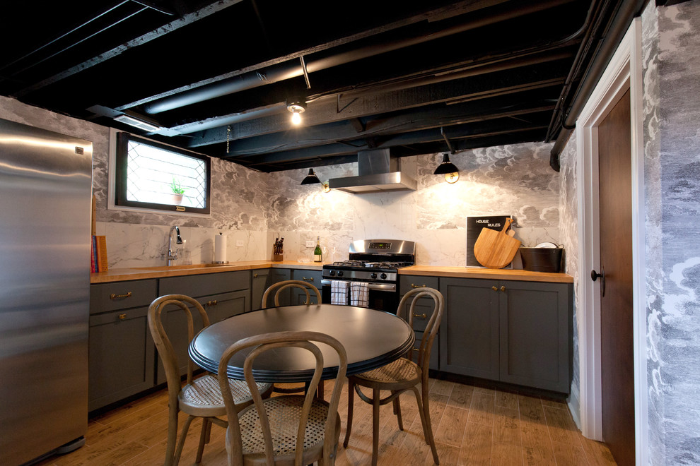 Mid-sized farmhouse look-out light wood floor, brown floor, exposed beam and wallpaper basement photo in Chicago with gray walls and a bar