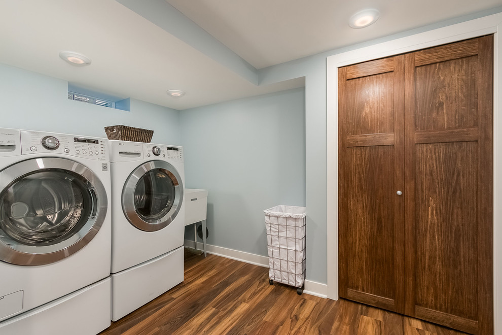 Inspiration for a large transitional medium tone wood floor and brown floor laundry room remodel in Minneapolis with blue walls