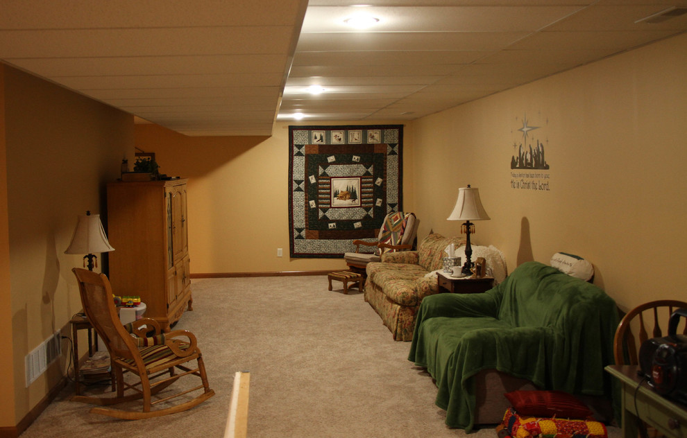 Klassisk inredning av en mellanstor källare utan fönster, med gula väggar, heltäckningsmatta och beiget golv