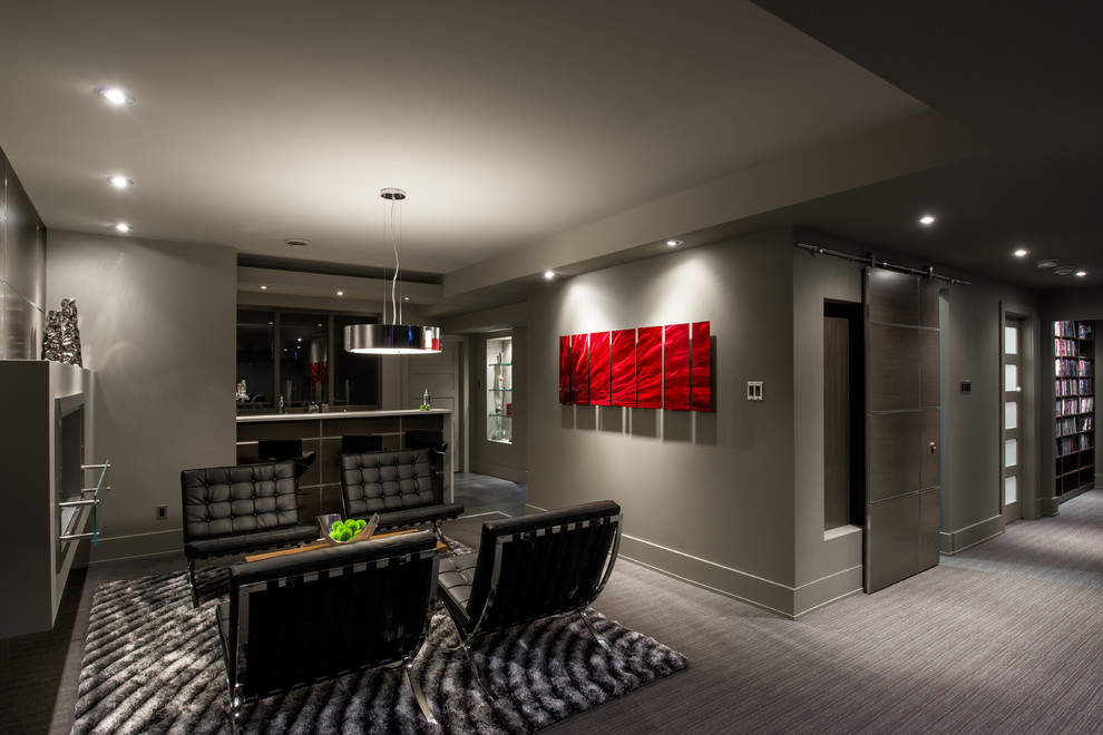 Modernes Untergeschoss mit grauer Wandfarbe, Teppichboden, Kaminumrandung aus Metall und grauem Boden in Ottawa
