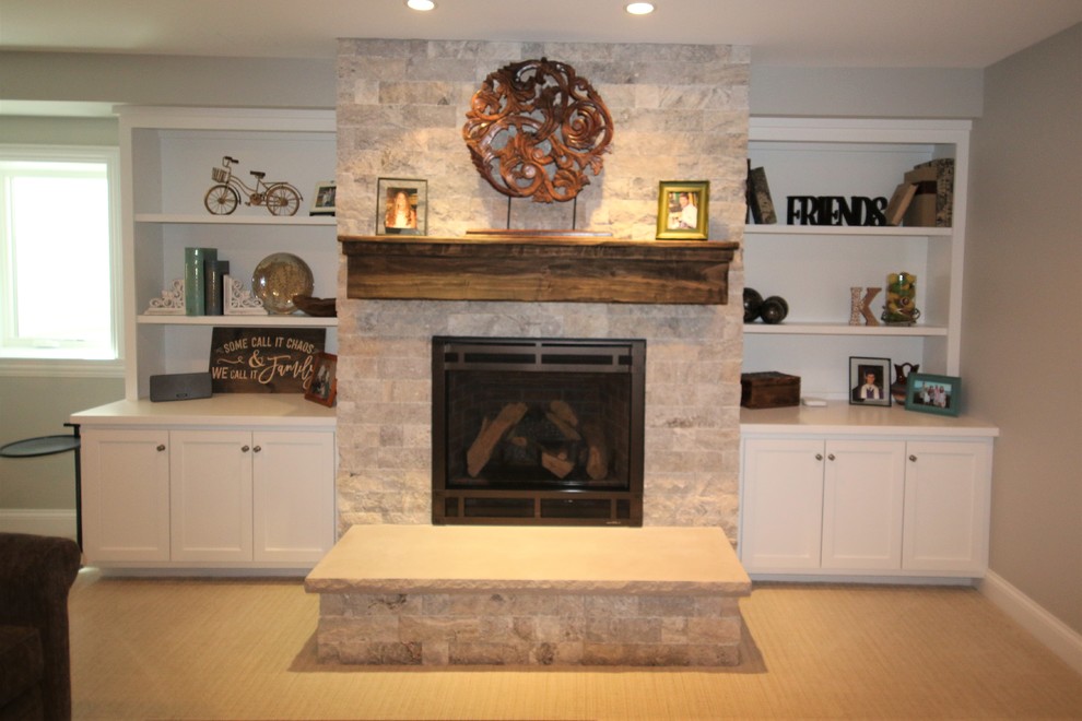 Idée de décoration pour un sous-sol tradition de taille moyenne et semi-enterré avec un mur gris, un sol en vinyl, une cheminée standard, un manteau de cheminée en pierre et un sol beige.