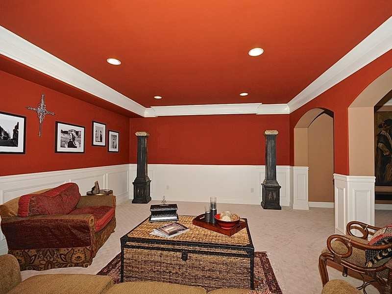 Exemple d'un sous-sol chic donnant sur l'extérieur et de taille moyenne avec un mur rouge, moquette et aucune cheminée.