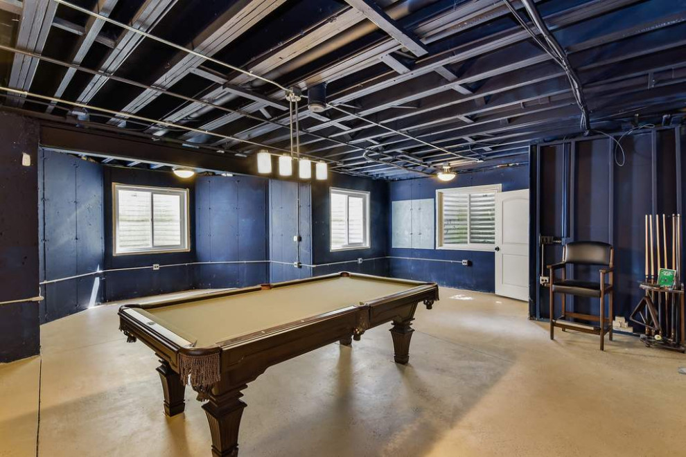 Large transitional concrete floor, beige floor and exposed beam game room photo in Chicago with purple walls