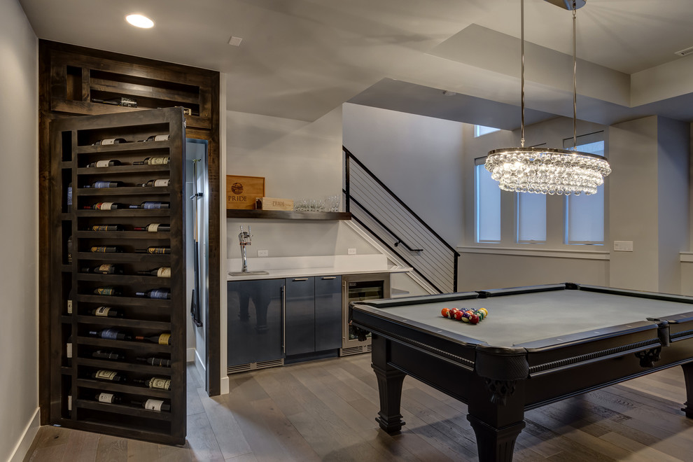 This is an example of a large traditional look-out basement in Denver with grey walls, medium hardwood flooring, no fireplace and beige floors.