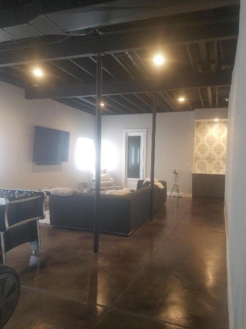 Large fully buried basement in Denver with concrete flooring and black floors.