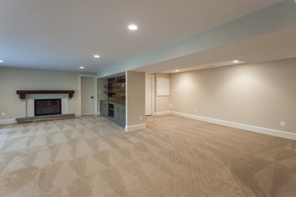 Classic walk-out basement in DC Metro with beige walls, carpet, a standard fireplace, a brick fireplace surround and beige floors.