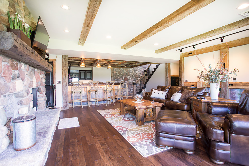 Inspiration for a large rustic walk-out basement in Other with white walls, dark hardwood flooring, a standard fireplace and a stone fireplace surround.