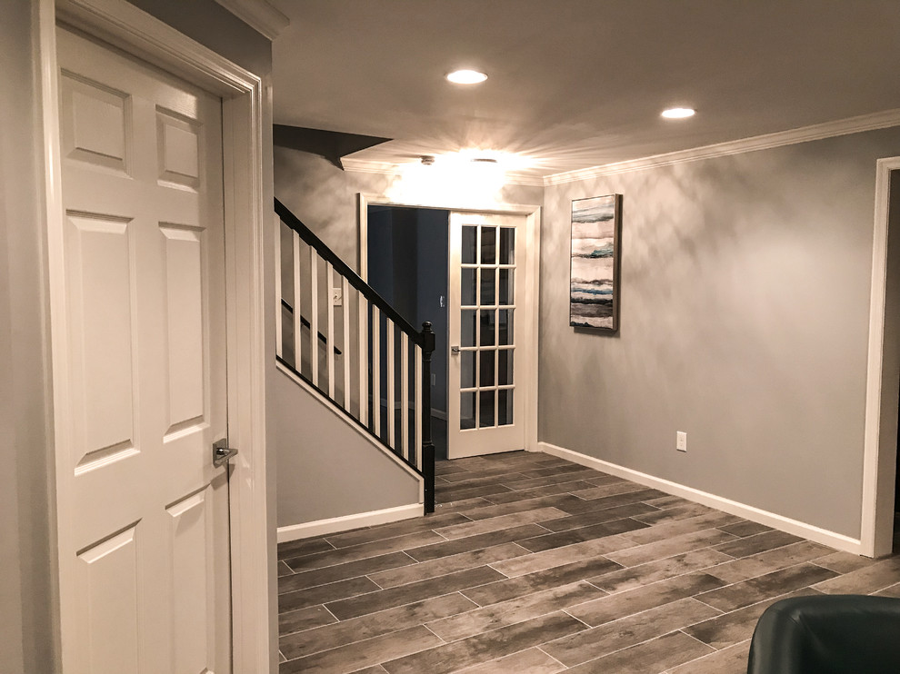 Basement - large traditional walk-out ceramic tile and gray floor basement idea in DC Metro with gray walls, a standard fireplace and a brick fireplace