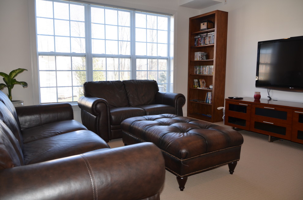 Cette photo montre un grand sous-sol tendance donnant sur l'extérieur avec un mur blanc, un sol en bois brun, un sol marron et boiseries.