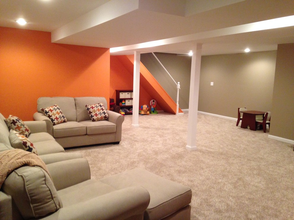 Large transitional underground carpeted basement photo in New York with beige walls and a standard fireplace