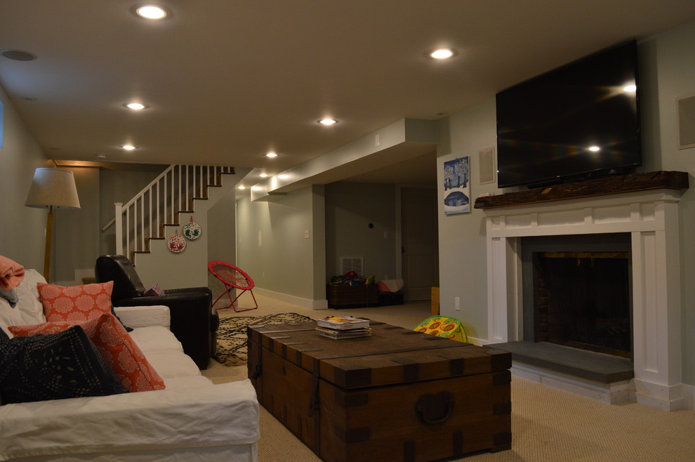 This is an example of a medium sized modern fully buried basement in Boston with green walls, carpet and a standard fireplace.