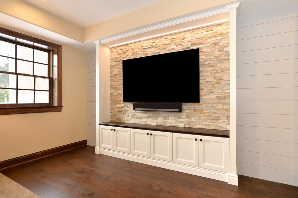 Medium sized traditional walk-out basement in Other with white walls, dark hardwood flooring, a standard fireplace, a stone fireplace surround and brown floors.