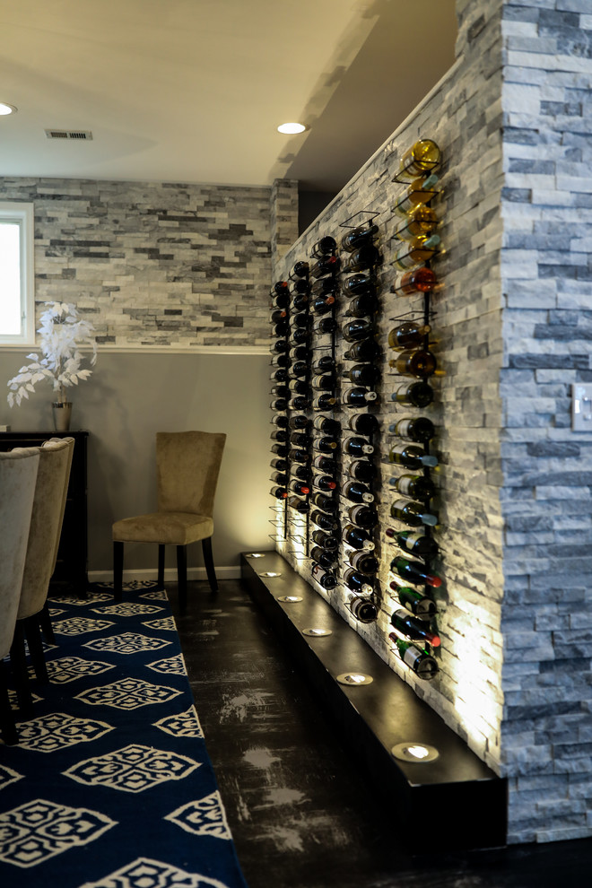 This is an example of a medium sized contemporary wine cellar in Cincinnati with concrete flooring and black floors.